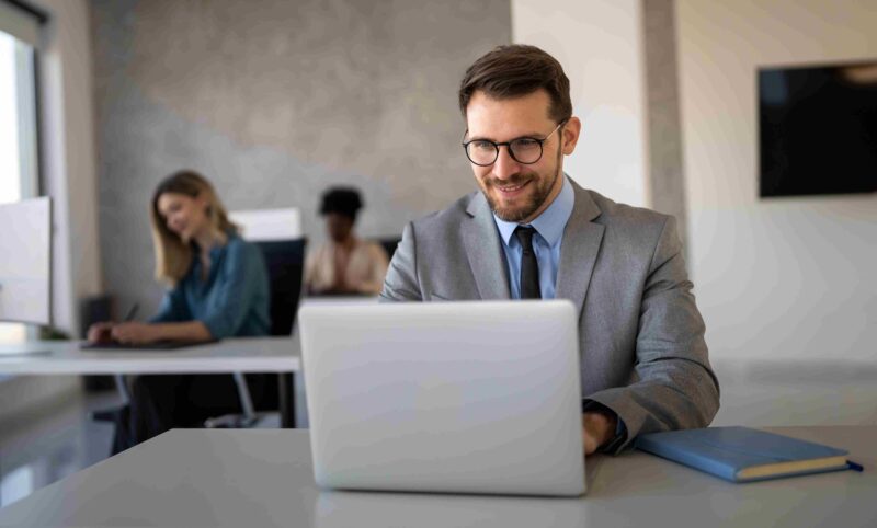 Business professional working on a laptop in an office while managing financial tasks