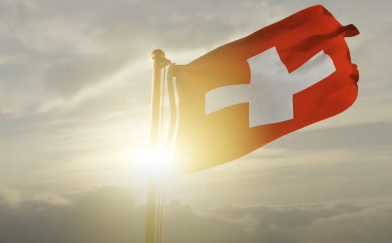 Swiss flag waving in a sunrise