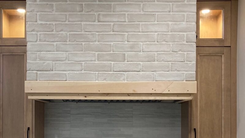 A kitchen range hood covered in thin white brick, blending rustic and modern styles