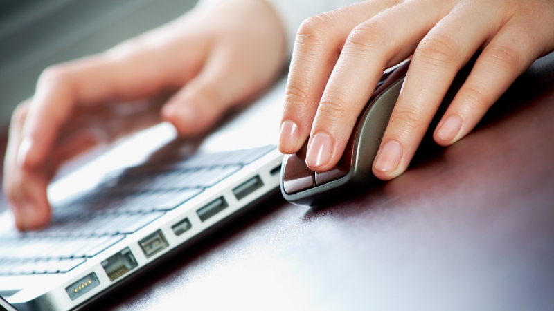 Hands using a mouse and keyboard, showing how first-click attribution influences marketing budget allocation