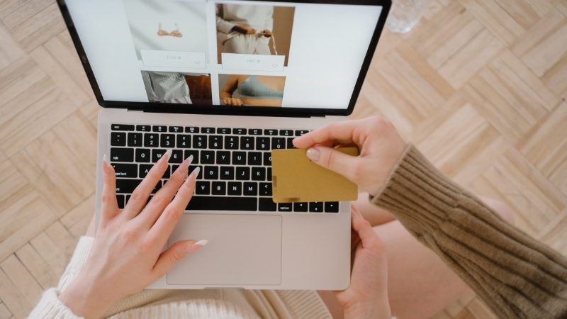 Two people shop online using a laptop and a credit card, showing how real purchase decisions involve more than one step