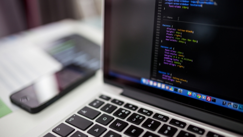 A laptop screen shows code in progress, highlighting tools used by students in STEM for coding and data analysis