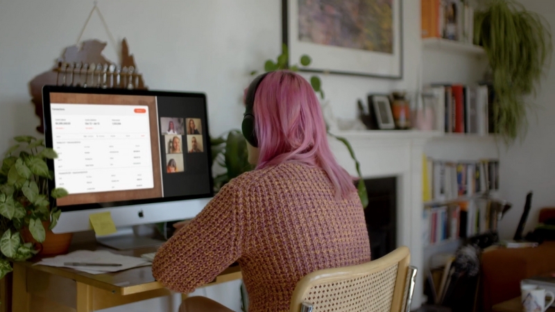 A woman on a video call reviewing cash flow documents on her computer