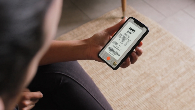 A person holding a smartphone and viewing a digital receipt