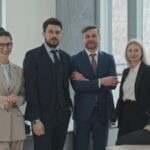 Five professionals posing in a modern office as a startup team ready for growth