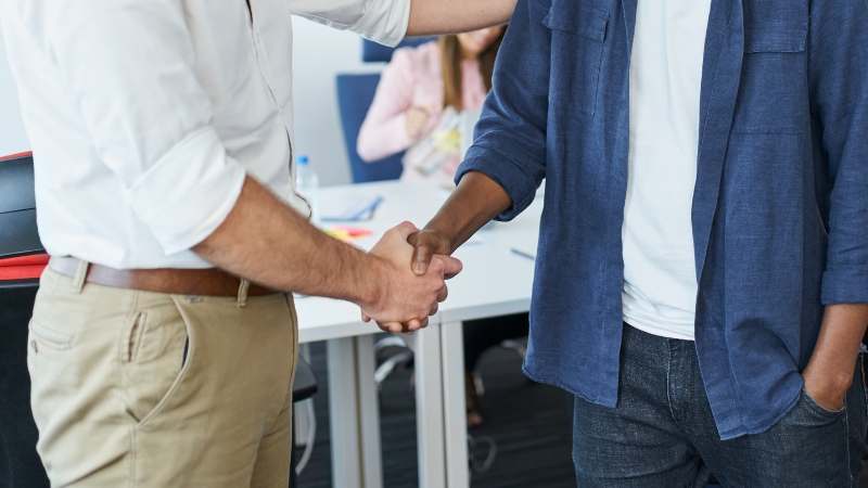 New startup team member shaking hands during onboarding in a modern office