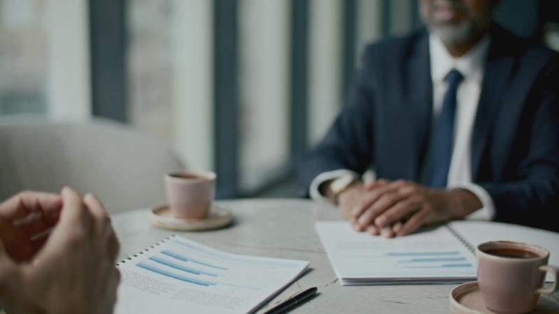 Two startup team members reviewing reports during a feedback meeting in an office