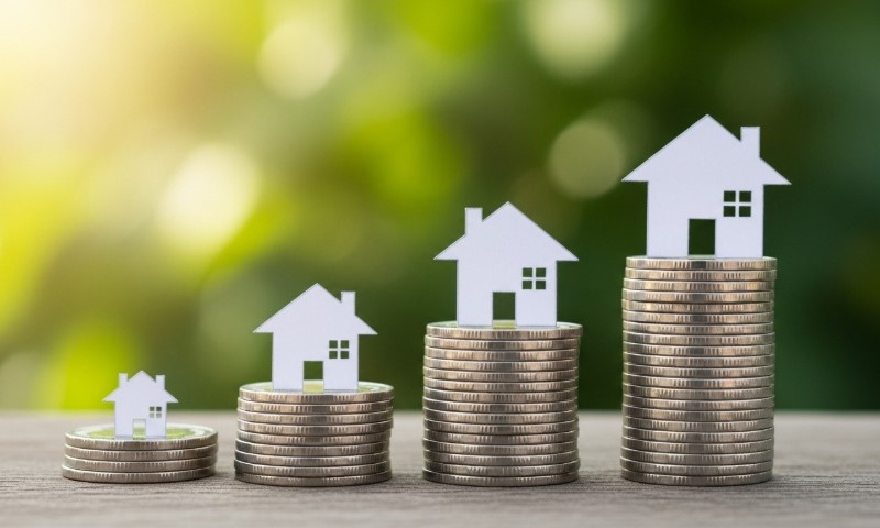 Three stacks of coins increase in height from left to right, each topped with a white house silhouette