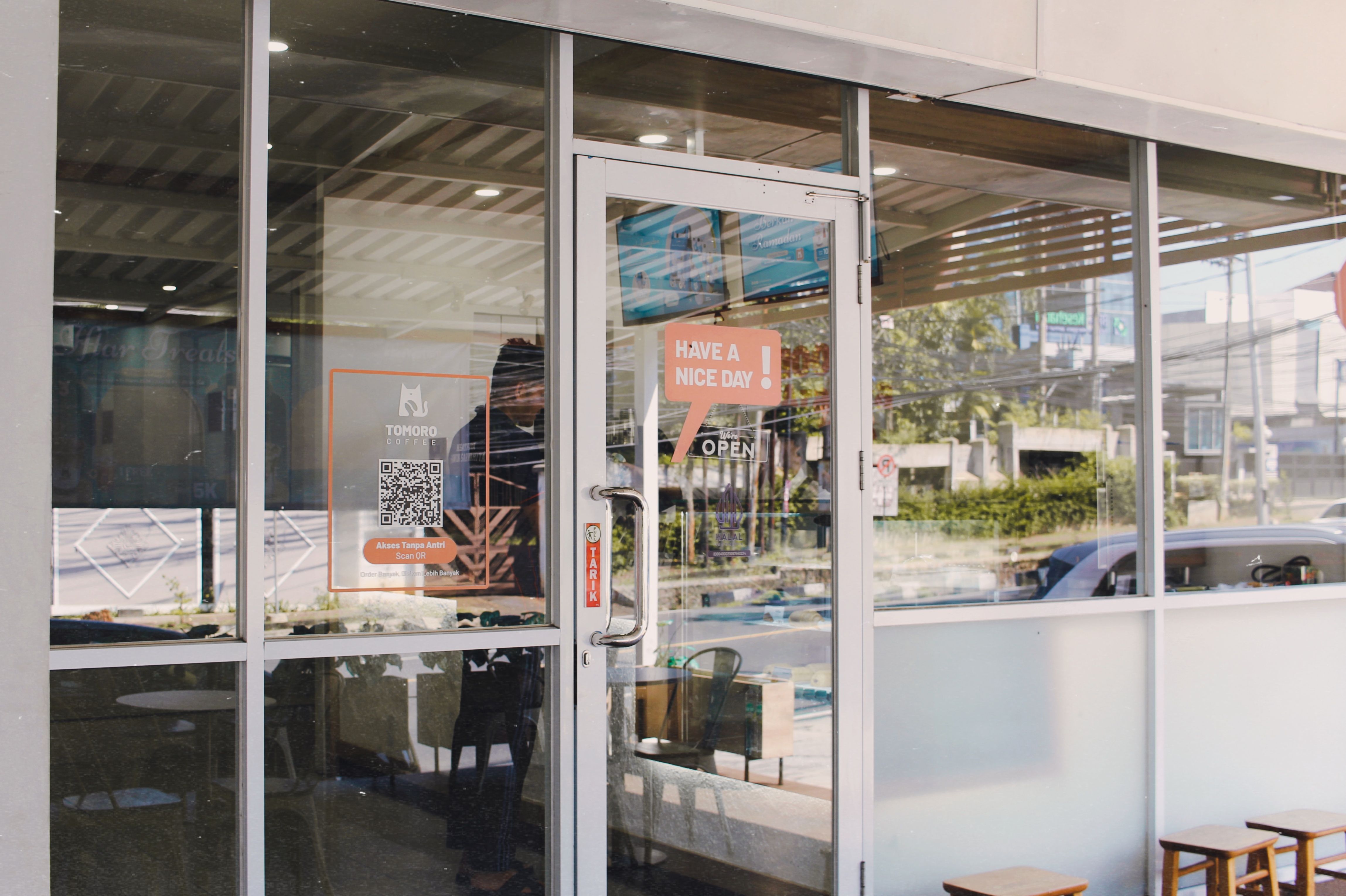 Glass door entrance to a cafe with signage reading 'Have a Nice Day'